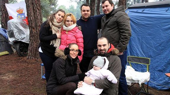 Uno de los grupos junto a sus tiendas, con la pequeña Dafne en brazos de su padre.