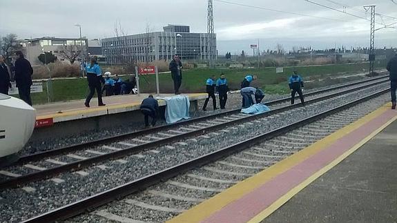 Agentes y testigos atienden a la víctima en el apeadero de la Universidad antes de la llegada de la ambulancia. 