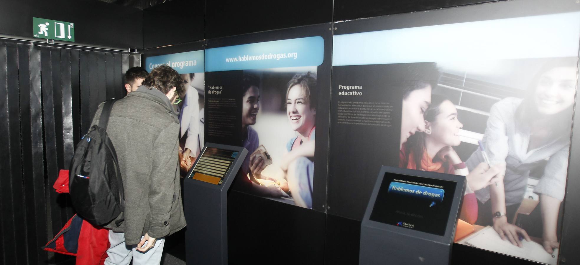 Dos visitantes observan uno de los paneles de la exposición. 