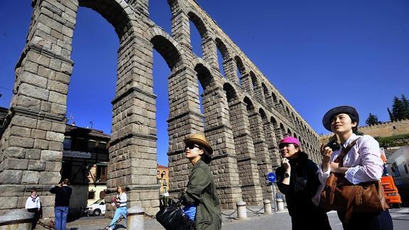 Tres turistas chinas pasean delante del Acueducto de Segovia. Fran Jiménez