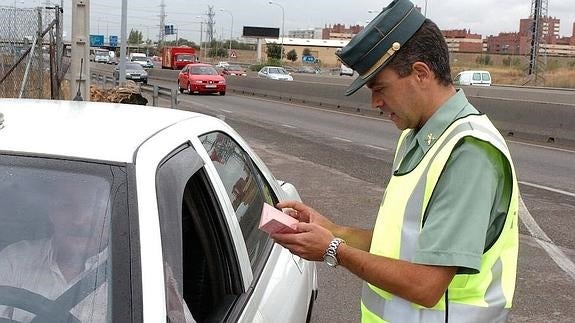 Un agentye conprueba la documentación de un conductor. 