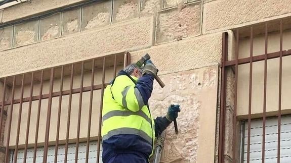 Un operario municipal destruye la placa con cincel y martillo.El Norte