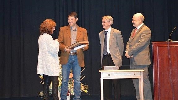 Antón Pombo, en el centro, recibe el galardón.