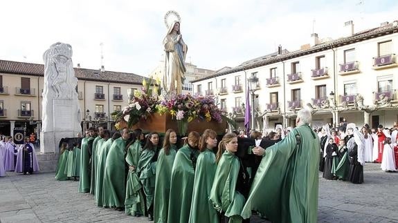 Hermanas de la Santa Vera Cruz mecen a la Virgen del Rompimiento tras despojarle del velo negro, en la Plaza Mayor de Palencia.