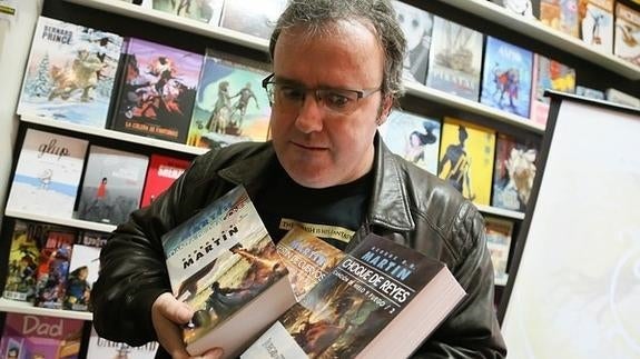 El dibujante vallisoletano Enrique Corominas, en la librería Parada Comics de Valladolid con algunos ejemplares de 'Juego de Tronos'. 