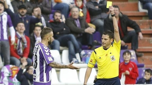 Figueroa Vázquez muestra la cartulina amarilla a Roger durante el partido ante el Numancia.