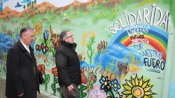 El delegado territorial de la Junta (derecha) y el presidente de la plataforma 'No más mierda' observan el mural que cubre la pintada aparecida recientemente. 