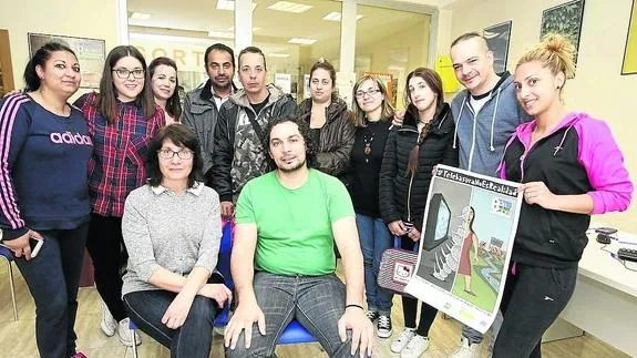 Personal profesional de la Fundación Secretariado Gitano de Salamanca y otras personas usuarias posan con el cartel del Día. 