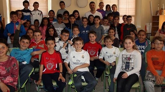 El exfutbolista César Jiménez (al fondo) posa con alumnos del centro Los Arenales de Cantalejo. M. Rico