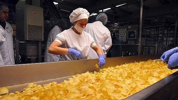 Una trabajadora selecciona patatas fritas en uno de los procesos.