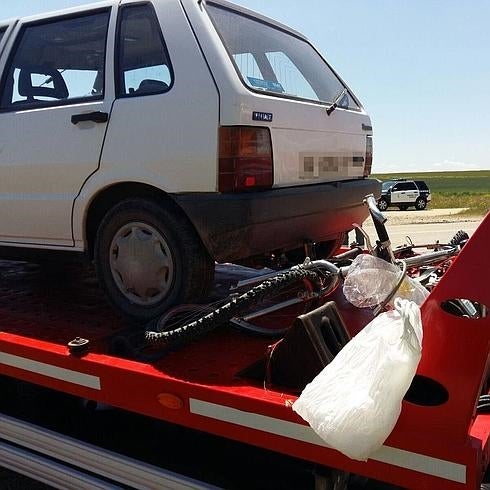 Una grúa retira el coche y la bicicleta implicadas en el siniestro.