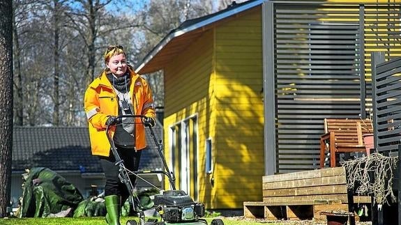Una cartera pasa el cortacésped en el jardín de un cliente del servicio postal finlandés