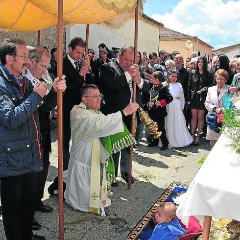 La procesión se detuvo en los dos altares, donde un niño nacido el último año esperaba recibir la bendición.
