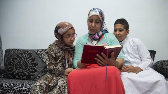 Fátima, junto a sus dos hijos, en un momento de lectura del Corán. ALBERTO MINGUEZA