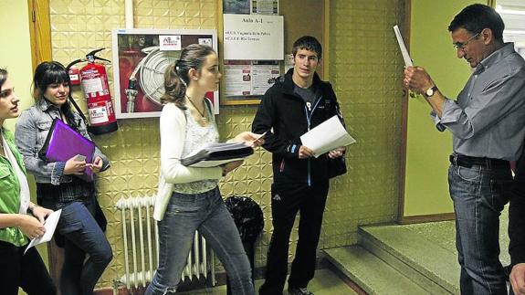 Un profesor lee en voz alta los nombres de los alumnos para regular el acceso al aula. 