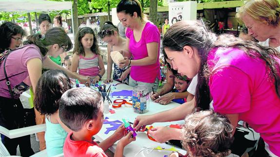 Las monitoras muestran a los pequeños cómo tienen que hacer las tareas en uno de los talleres. M. Rico