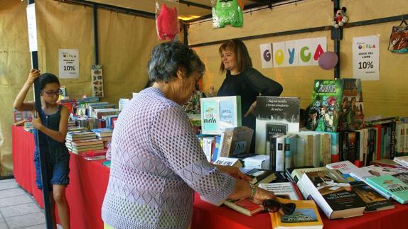 Una mujer mira los libros en un puesto de la feria. 