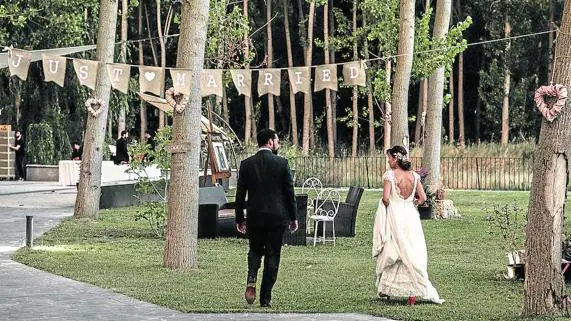 Una pareja pasea por los jardines de El Molino de Torquemada, en el día de su boda.