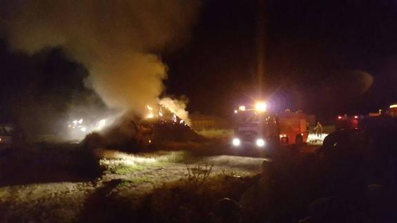 Los bomberos tratan de sofocar las llamas declaradas en el pajar de un activista de 'No Más Mierda', este sábado. 