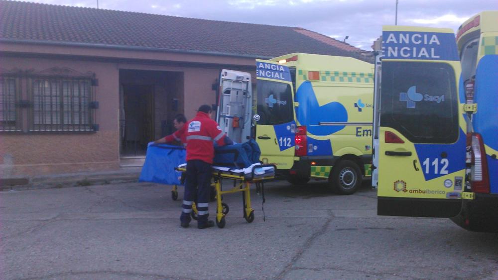 Unos trabajadores se disponen a trasladar a un herido. 