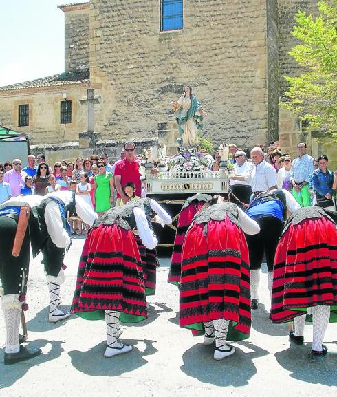 Un grupo de danzas frente a la imagen de la patrona. 