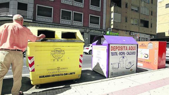 Imagen de los contenedores en los que se recoge la ropa. (blanco) y el aceite (naranja).