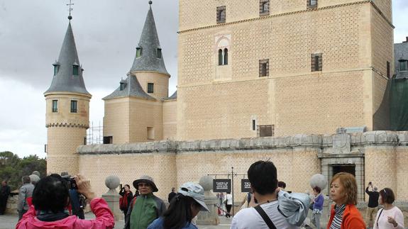Grupos de turistas asiáticos toman fotografías en el exterior del Alcázar de Segovia