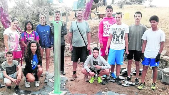 Jóvenes trabajando en el nuevo proyecto dentro del círculo de árboles rojos.