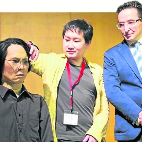 Hiroshi Ishiguro, junto al robot ante la mirada de Corchado.