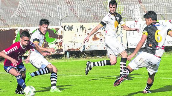Un jugador del Real Ávila intenta marcharse de los zagueros de Unionistas Sito Cruz, Antonio León y Chamorro.