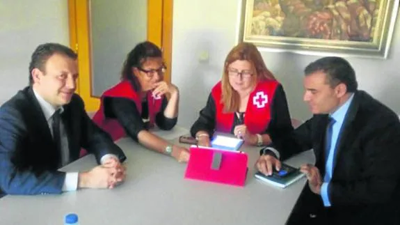 Miguel Oscar Rivas y Narciso Fidalgo, de La Caixa, conversan con Montserrat Juanes y Nieves del Amo en la sede de Cruz Roja.