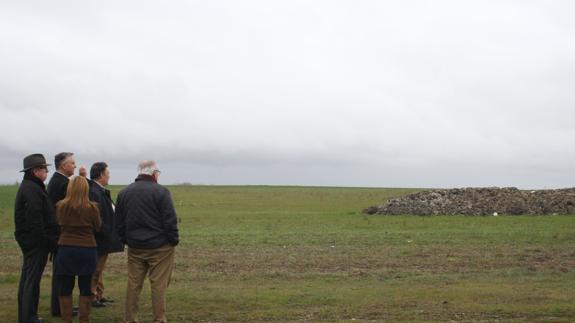 El delegado de la Junta, los técnicos y algunos vecinos observan los montones en una visita a los terrenos. 