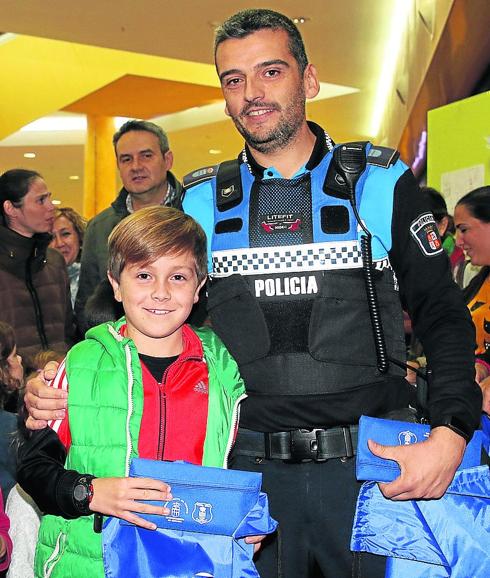 Un policía local, con uno de los niños distinguidos. 