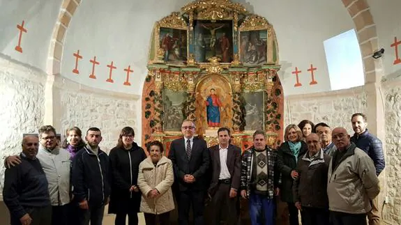El delegado de la Junta, en el centro, con representantes del Obispado y de la localidad, delante del retablo. 