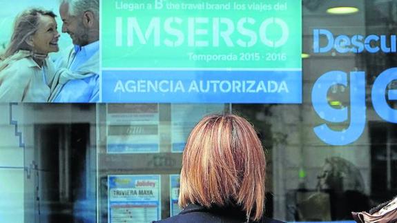 Una mujer, frente a una agencia de viajes que promociona el programa del Imserso. 