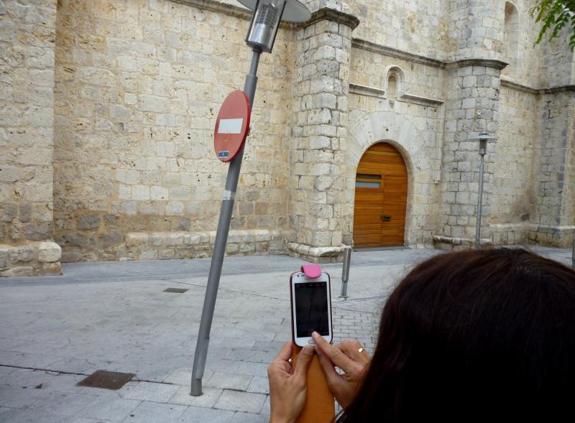 Una vecina comunica a través del móvil la incidencia de una farola torcida.