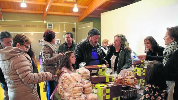 Un grupo de visitantes hace sus compras en la feria, en la que se paga con unos tíquets adquiridos en el mismo lugar.
