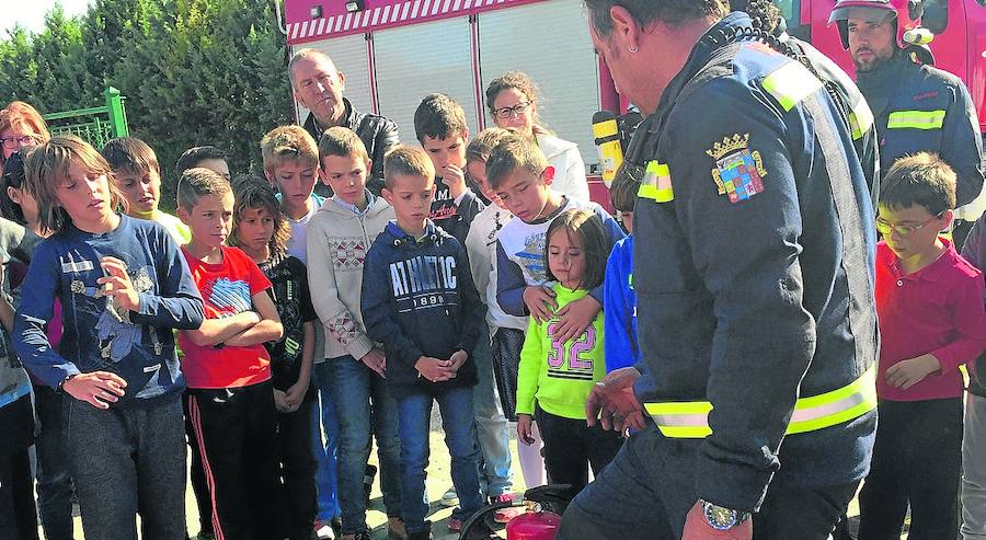 Los escolares escuchan las explicaciones de los bomberos en las jornadas.