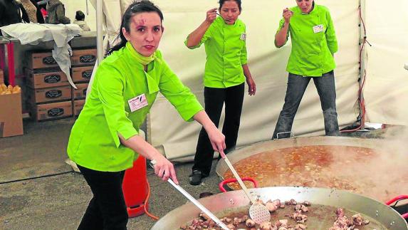En primer término, María Duque, gerente de Catering Segovia, prepara una caldereta. 