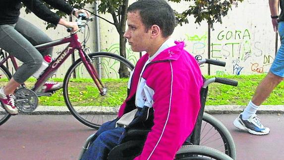 Un joven pasea en silla de ruedas. 