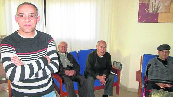 José Antonio Belda, en la sala principal de la casa asistida, junto a varios residentes.