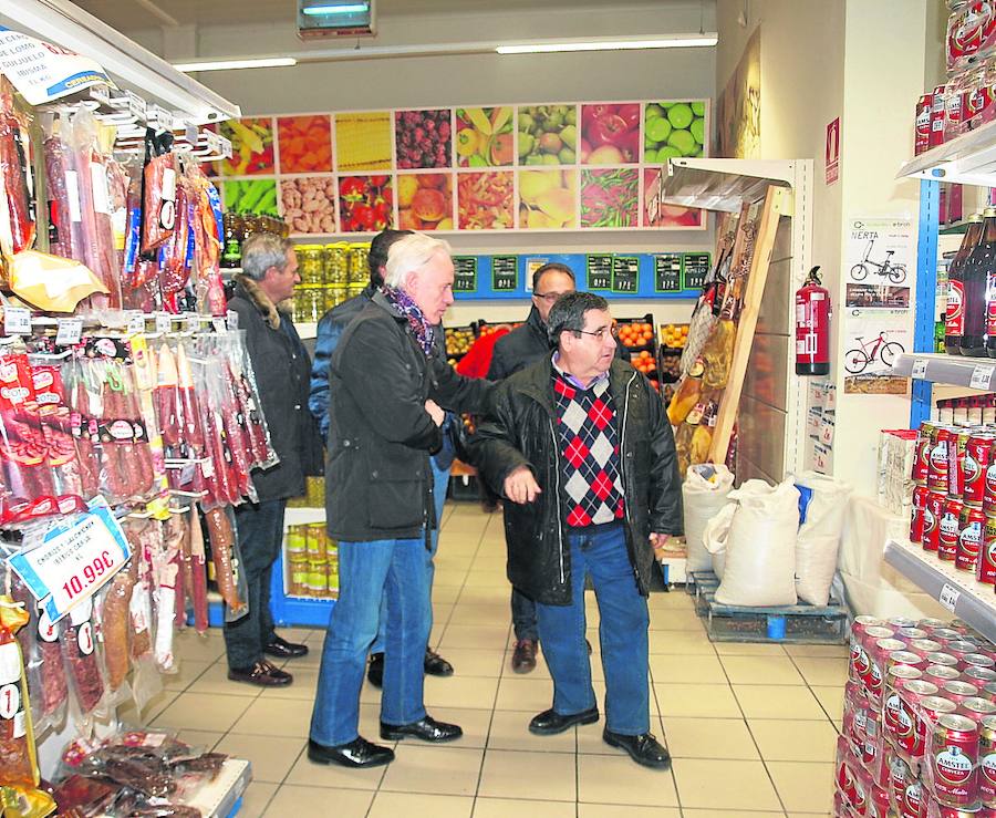 El presidente de Agropal, Lucas Ferreras, enseña el supermercado de Baltanás al delegado de la Junta.