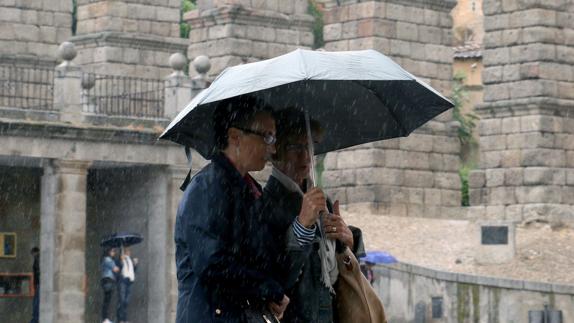 Dos personas se protegen de la lluvia. De Torre