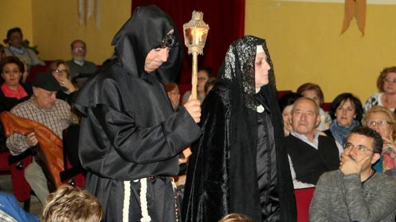 El sacerdote acompaña a la reina Juana a velar a su esposo.
