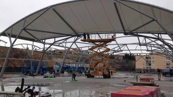 Varios operarios proceden a la colocación de la cubierta textil en la campa de la estación. 