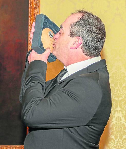 Víctor Reyes besa emocionado la Estrella de Oro que recibió del alcalde. 