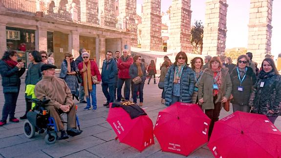 Las gúias oficiales de turismo, detrás de los paraguas rojos, en la plaza del Azoguejo. M. Á. López