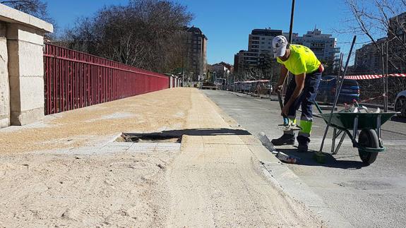 Los operarios rematan la acera del lado izquierdo del puente del Poniente