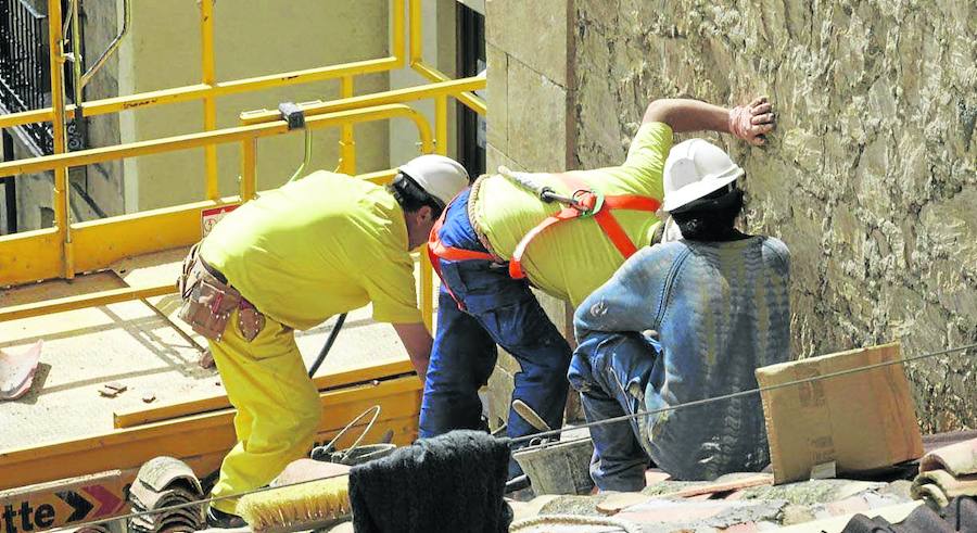 Tres empleados del sector de la construcción, durante su quehacer cotidiano en una obra en la capital salmantina. 