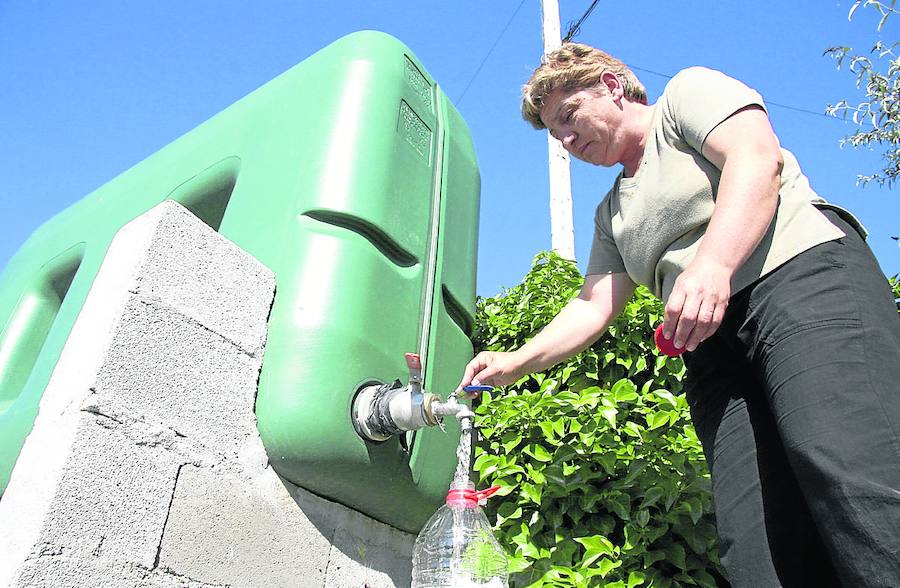 Una mujer de Buenamadre cogiendo agua de un depósito al que se llevó este líquido en cisternas. 